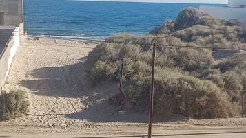 A beach with a sign indicating proximity to a beach.