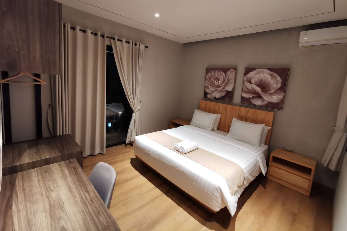 Une chambre à coucher moderne avec un lit en bois, un bureau et une chaise.