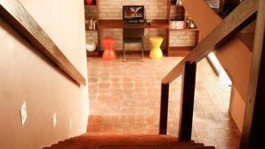 A staircase leading to a room with a brick wall and a sign that reads "ESTANCJE LA SUE."