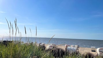 Ein Strand mit einer Reihe von Briefkästen und blauem Himmel.