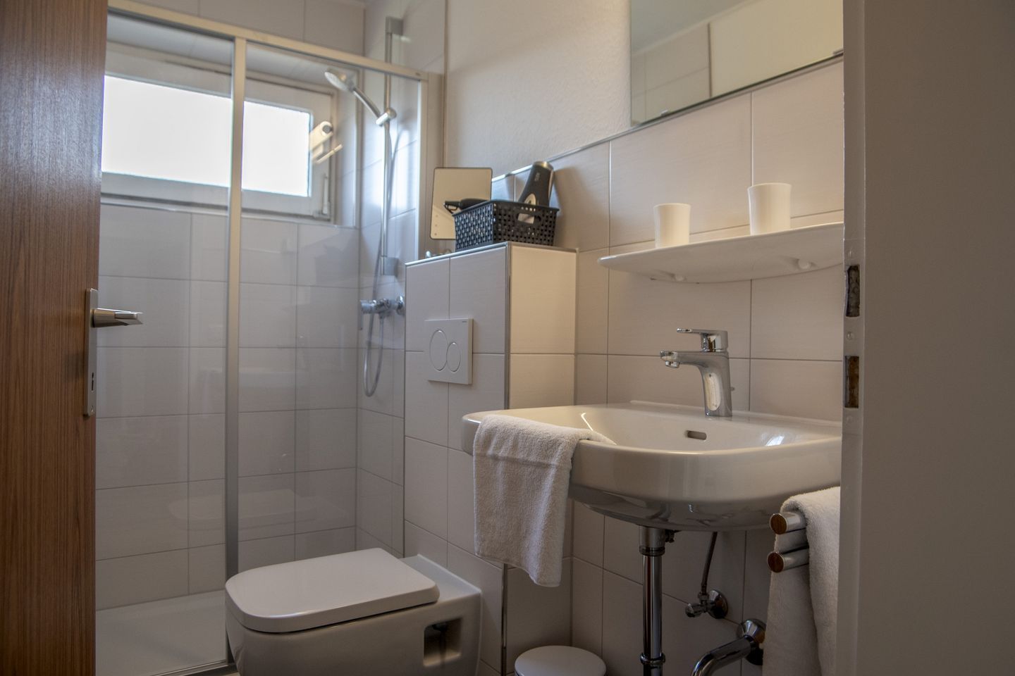Ein Badezimmer mit Dusche, Toilette, Waschbecken und Handtuchhalter.
