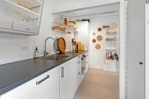Eine moderne Küche mit weißen Schränken, einer Granitabdeckung und verschiedenen Küchenutensilien sowie Dekorationen.
