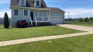 A single-story house with a front porch, a garage, and a well-maintained lawn. - Harbor Escape- Minutes to beaches, Arts District, Harbor Shores & St Joseph (Benton Harbor)