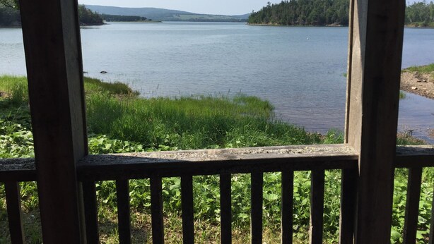 A view of a lake from a wooden deck with a railing. - Beachfront Guest Cottage in Antigonish (Antigonish)