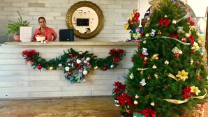 Uma área de recepção com uma árvore de Natal, um espelho e um letreiro que diz "SANTA'S STOP HERE".