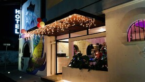 Entrada de hotel com um mural, luzes de cordão e decoração de Natal.