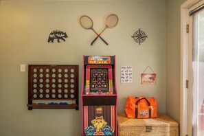 Ett rum med en Pac-Man-spelautomat, två badmintonracketar, en kompass, en korg och en Jenga-påse.
