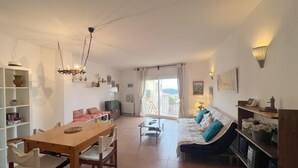A spacious living area with a dining table, sofa, and TV. - Rental apartment with community pool in Begur (Begur)