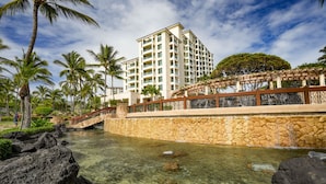 A resort with a clear pool, palm trees, and a stone bridge. - Maui Resort Rentals: Marriott's Ko Olina Beach Club Studio Ocean View Villa (Oahu)