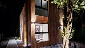 A modern two-story building with large windows and a wooden exterior. - Modern 2 Bedroom Villa - 10 min. Walk to the Beach (Playa Potrero)