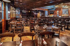 Ein Restaurantinneres mit Holztischen und -stühlen, einer Bar und einer Speisekarte.