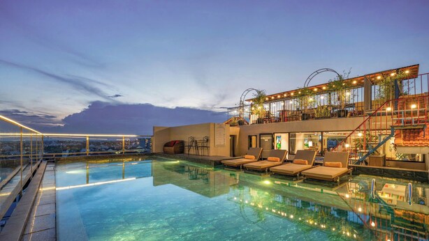A rooftop infinity pool with lounge chairs, a staircase, and a glass balustrade. - Soleil by Soluna - A Charming Touch of Hoi An's Heritage (Da Nang)