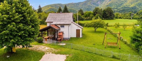 Ett hus med en trädgård, en gunga och en stig som leder fram till huset.