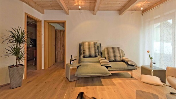 A cozy living room with a sofa, a coffee table, and a wooden floor. - Holiday Apartment 'Albfewo' with Terrace, Garden and EV Charging Station (St. Johann)