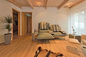 Un salon chaleureux avec un canapé, une table basse et un plancher en bois.