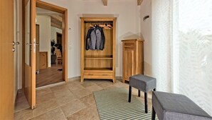 A room with a wooden wardrobe, a bench, and a tiled floor. - Holiday Apartment 'Albfewo' with Terrace, Garden and EV Charging Station (St. Johann)