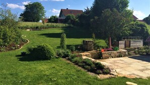 A well-maintained garden with a lawn, stone pathway, and a stone structure. - Holiday Apartment 'Albfewo' with Terrace, Garden and EV Charging Station (St. Johann)