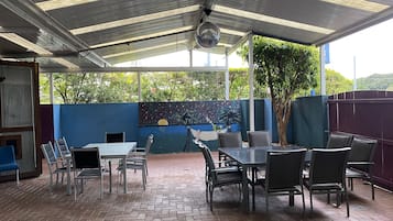 A covered patio area with a table and chairs, a disco ball, and a mural on the wall.
