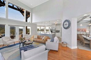 A spacious living area with a large window, a kitchen, and a dining area. - Mount Finlayson View Villa (Victoria)