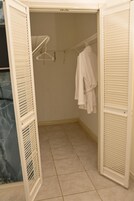 Un vestidor con una barra para colgar ropa y una bata en un perchero.