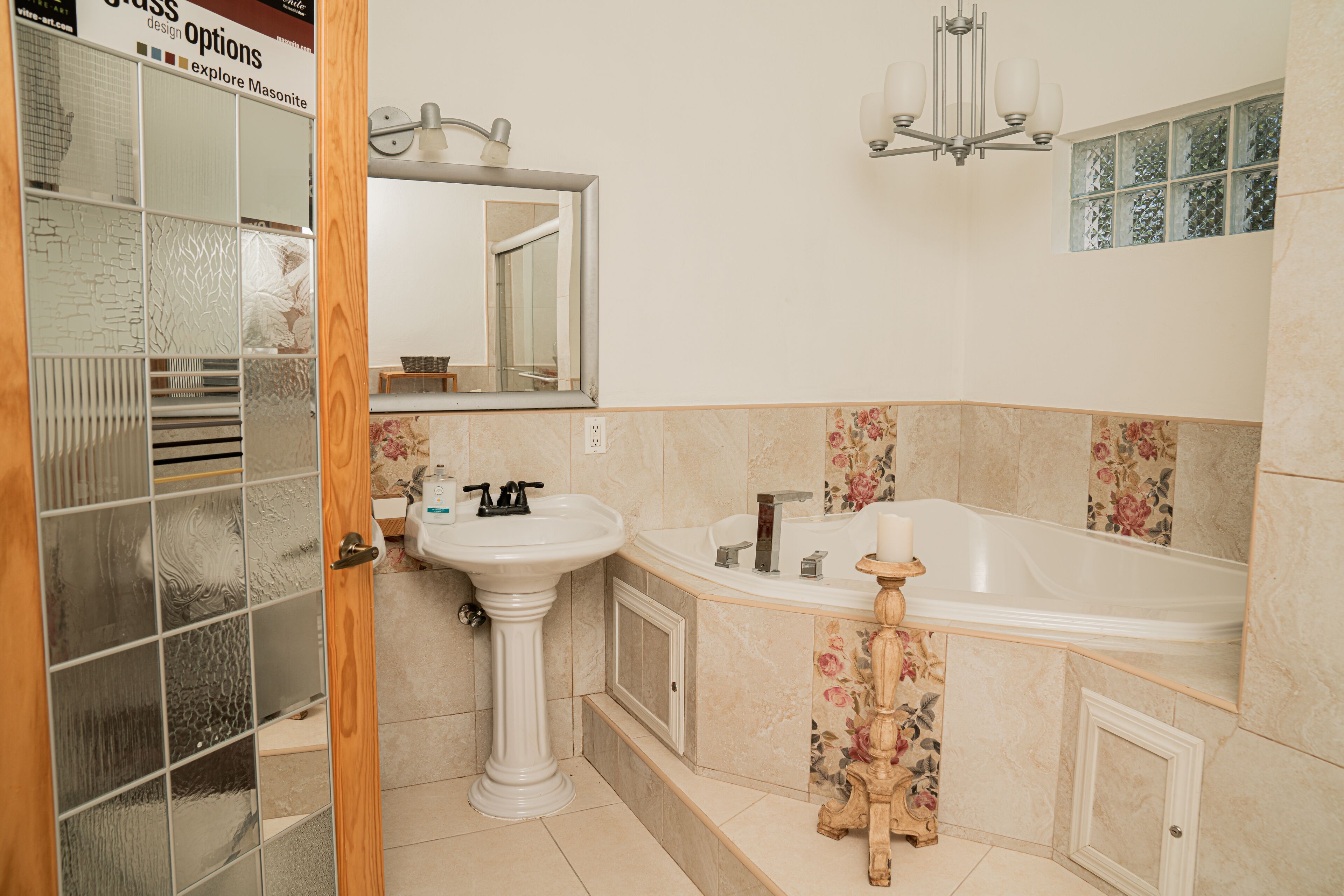 Un baño con lavamanos, espejo y bañera.