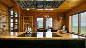 Una cocina con una isla grande, paredes de madera y vistas al exterior.