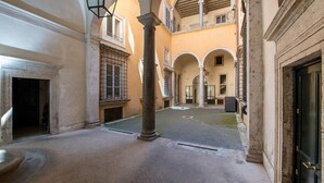 Un patio con una fuente, columnas y una puerta.