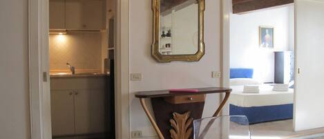 Ein Hotelzimmer mit Bett, Nachttisch, Spiegel und Blick ins Bad.
