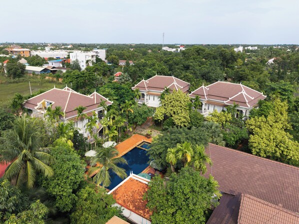 A residential area with multiple houses, a swimming pool, and lush greenery. - SANNA VILLA Residence (Siem Reap)
