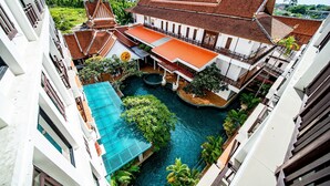 Un patio con piscina, rodeado de edificios de arquitectura tradicional y vistas a la ciudad.