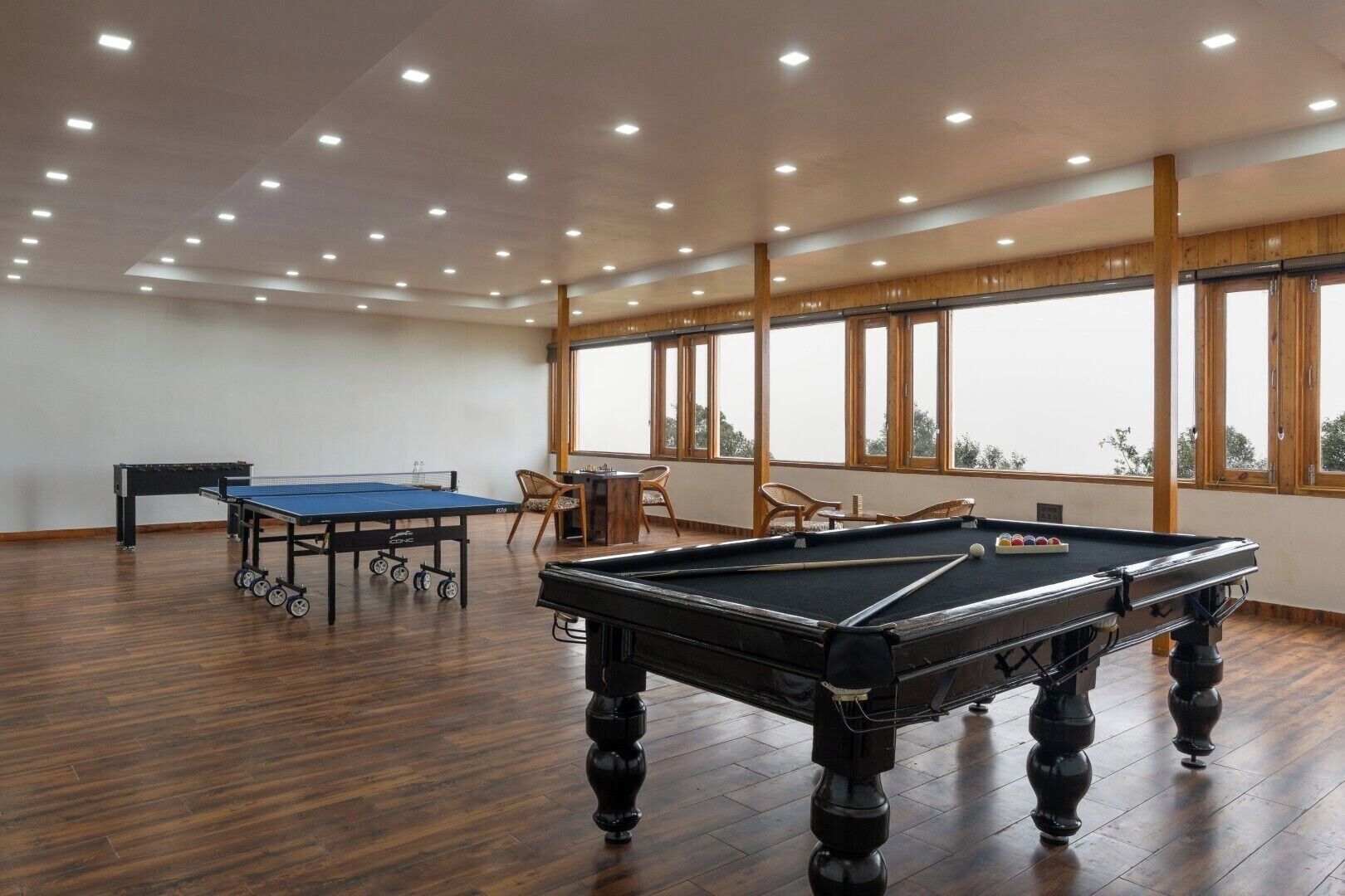 Un'ampia area interna con tavolo da biliardo, tavolo da ping pong e tavolo da snooker.