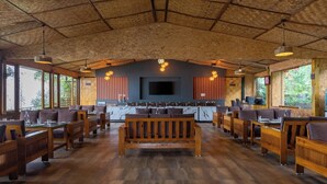 A spacious restaurant with wooden furniture, large windows, and a central seating area. - Aotel Pangot (Formerly Royal Cliff) (Nainital)