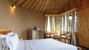 A bedroom with a bed, a nightstand, a wooden wardrobe, and a window with curtains. - Aotel Pangot (Formerly Royal Cliff) (Nainital)