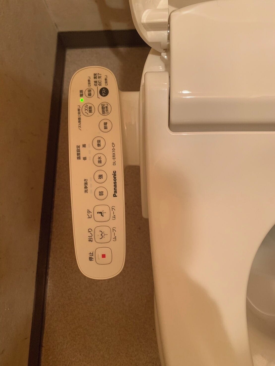 A toilet with a control panel featuring buttons for functions like flush, bidet, and seat heating.