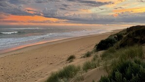 Una playa con una orilla de arena y dunas cubiertas de hierba.
