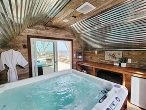 Relax in a spacious hot tub with jets, surrounded by a serene outdoor area.