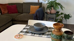 A dining area with a checkered tablecloth, a bowl, a vase, and a plate with a floral design. - Studio 59 - Byron Hinterland. (Myocum)