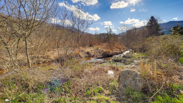 A natural landscape with a stream, trees, and mountains in the background. - Mtn-View Condo w/ Lookout Deck in Banner Elk! (Banner Elk)