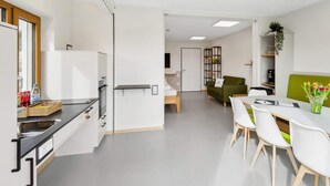 Una cocina moderna con comedor, un sofá y una pequeña mesa con sillas.