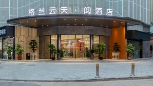 A hotel entrance with a modern design, featuring a curved facade and large glass windows. - Grand Yuntian Yue Hotel Shenzhen Shekou  (Shenzhen)