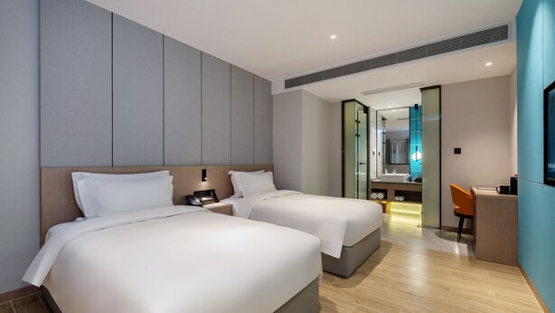 A modern hotel room with two beds, a desk, and a bathroom visible through a glass door. - Grand Yuntian Yue Hotel Shenzhen Shekou  (Shenzhen)