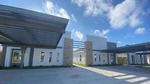 A modern building with a covered parking area and multiple entry points.