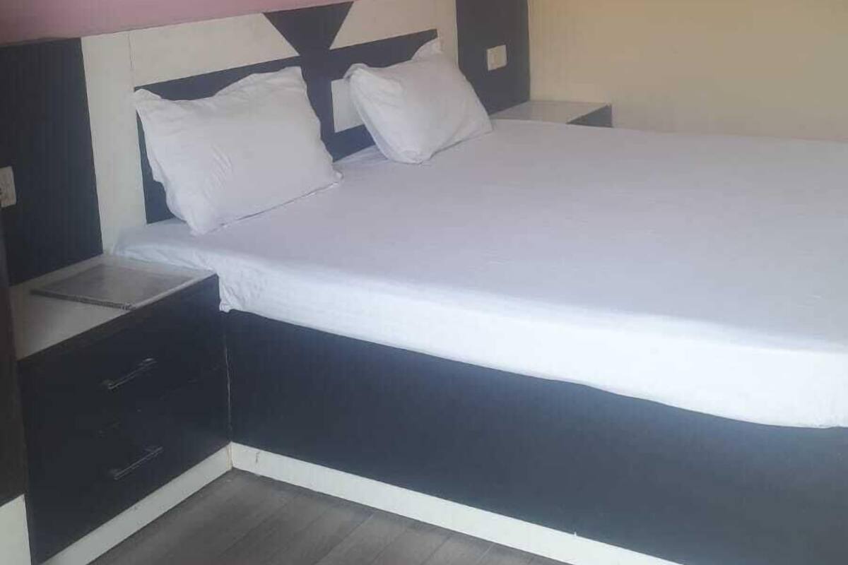 A bedroom with a bed, nightstands, and a wooden floor.