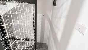 A staircase with a white wall and a black railing.