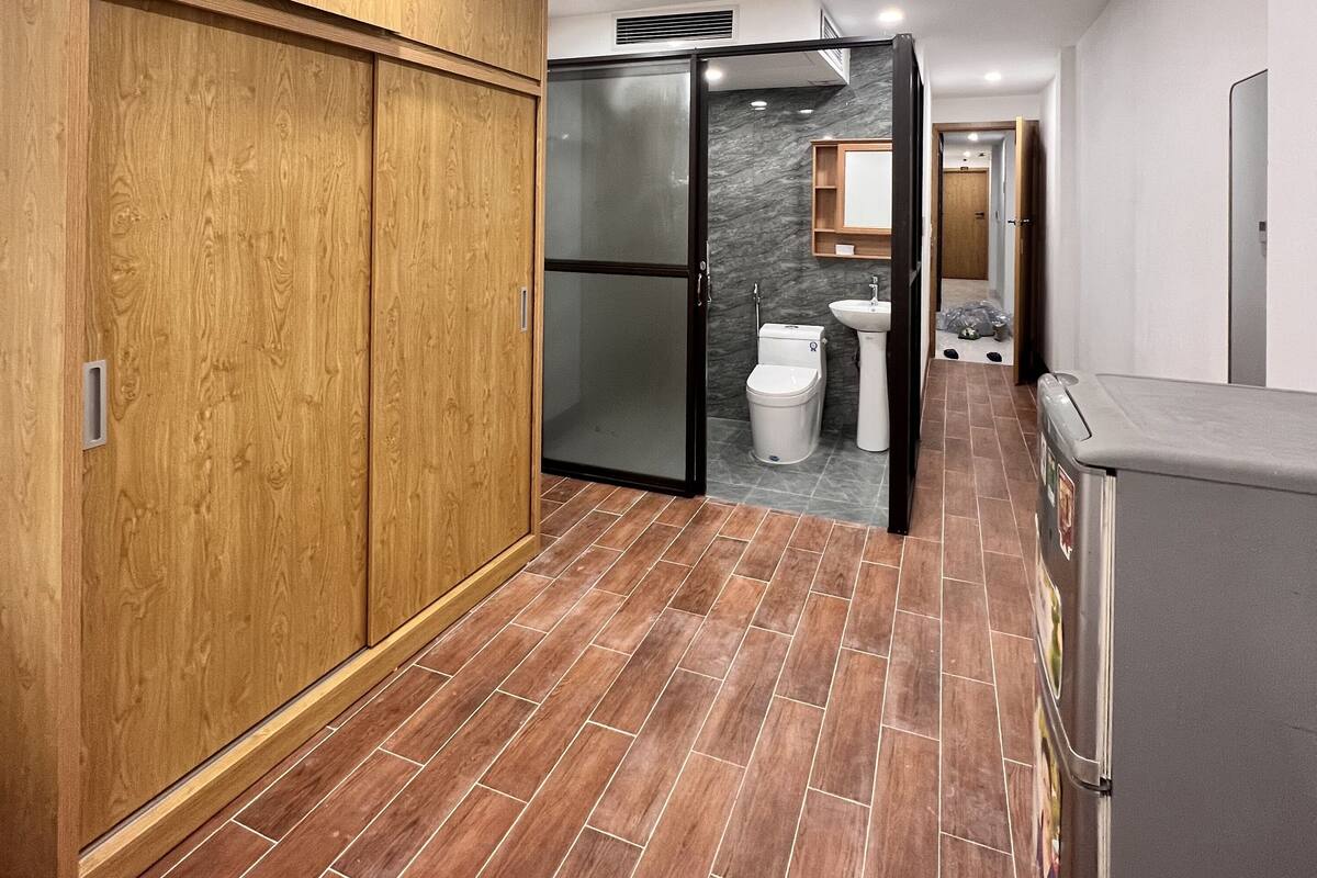 A modern kitchen with a refrigerator, wooden cabinets, and a tiled floor.