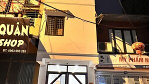 A building with a sign for 'QUAN SHOP' and another sign for 'MY PHAM N'.