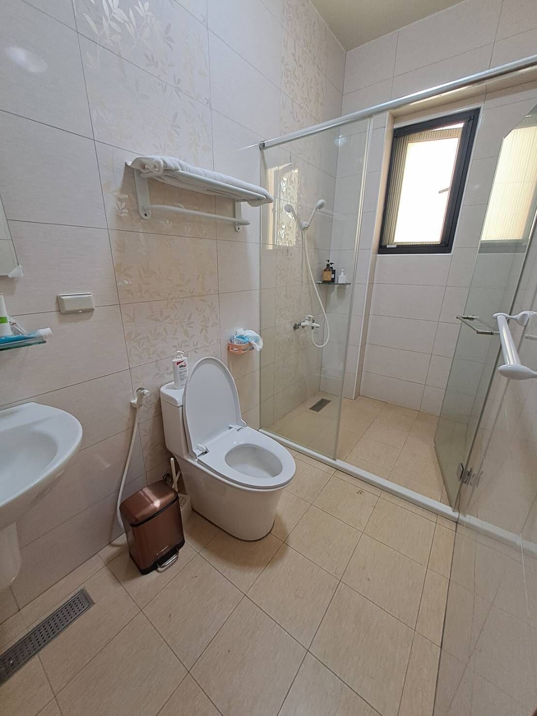 A modern bathroom with a toilet, bidet, and glass shower enclosure.