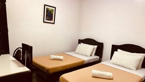 A room with two single beds, a small table, and a chair. - Stonewood Hotel (General Santos)