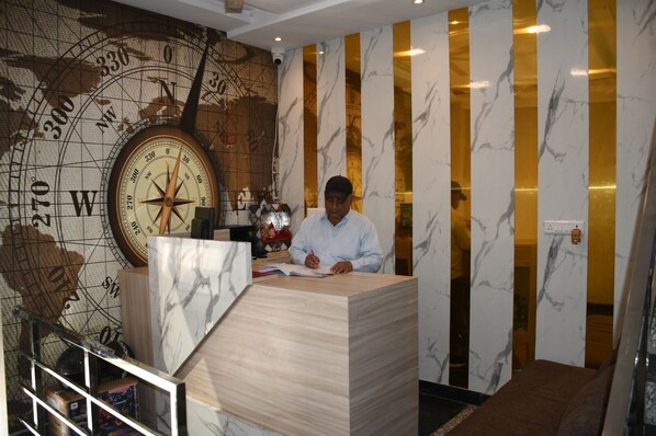 A man sitting at a desk with a large compass map in the background.