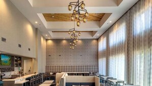A modern restaurant with a wooden ceiling, a patterned wall, and a seating area with tables and booths. - Hampton Inn and Suites South Lake Tahoe (South Lake Tahoe)